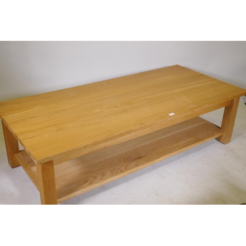 1180 - A solid golden oak two tier coffee table, bears label New Forest Furniture Ltd, 66