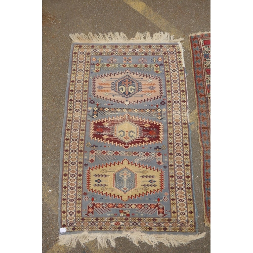 1182 - A Persian blue ground wool rug with geometric medallions and stylised birds design, a red ground Her... 