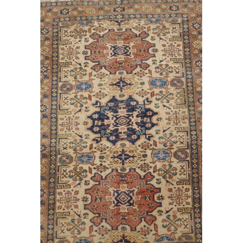 1188 - A gold ground wool Bokhara carpet, signed, 52