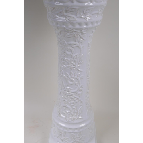 39 - A German white glazed pottery jardiniere on stand with embossed flower and vine decoration, 67cm hig... 