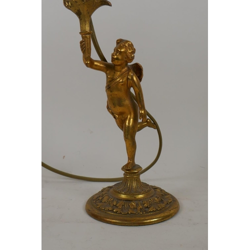 56 - A brass table lamp in the form of a putto bearing a torchere, 24cm high