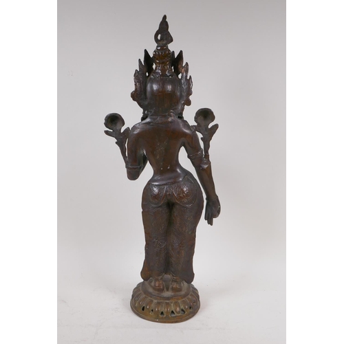 69 - An antique bronze figure of Shiva, standing upon a dais, 50cm high