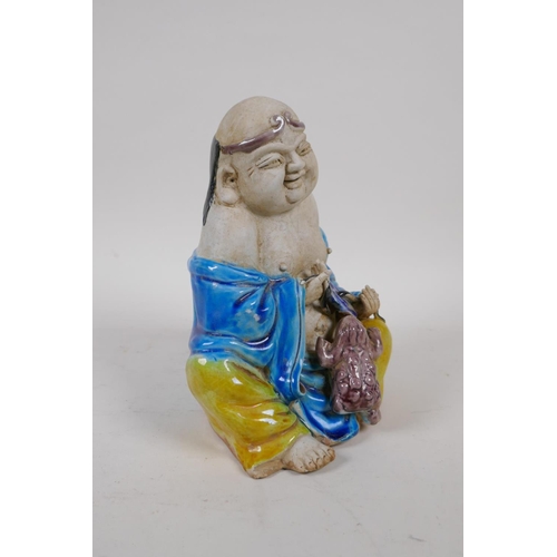 70 - A Chinese Sancai glazed porcelain Lohan figure, 17cm high