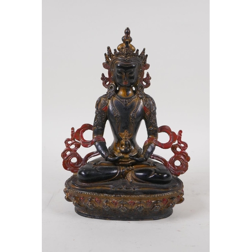 71 - A Sino Tibetan bronze figure of Buddha with gilt and coppered patina, 21cm high