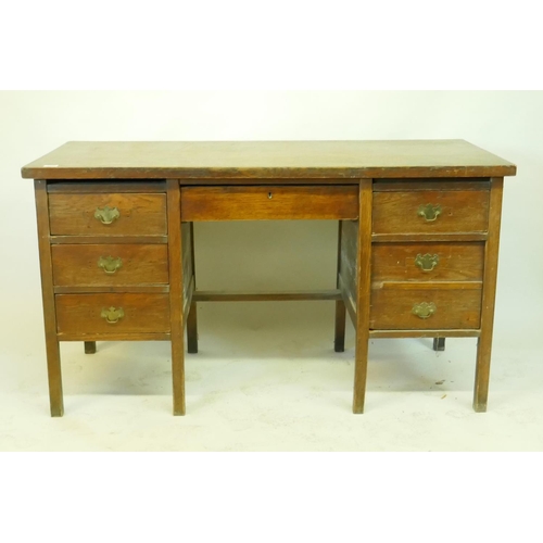 1199 - An oak office desk of five drawers, raised on square supports, early C20th, 138 x 62 x 77cms