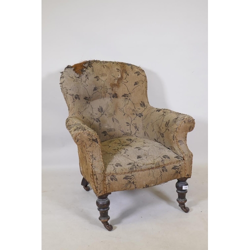 1200 - A Victorian easy chair with shaped back and scroll arms, raised on turned supports with brass castor... 