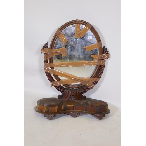 1204 - A C19th mahogany swing toilet mirror, with oval mirror and two wells, AF, 85cm high