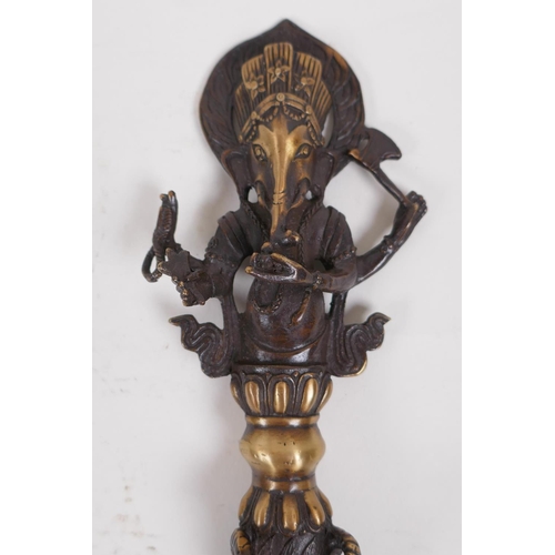 16 - A Tibetan bronzed metal phurba, the handle in the form of Ganesh, 32cm long