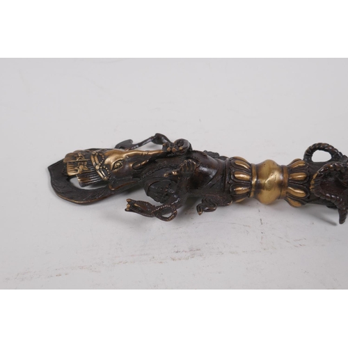 16 - A Tibetan bronzed metal phurba, the handle in the form of Ganesh, 32cm long