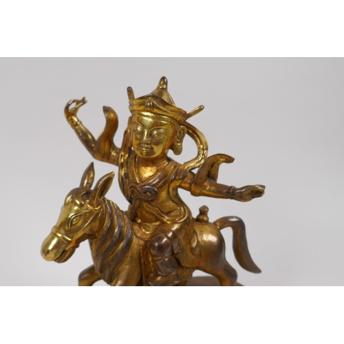 17 - A Chinese gilt bronze figure of a deity on horseback, 23cm high