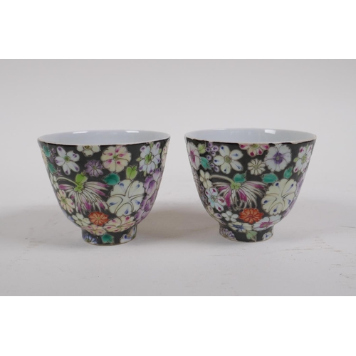 18 - A pair of late C19th/early C20th famille noir porcelain tea bowls with floral decoration, Chinese Gu... 