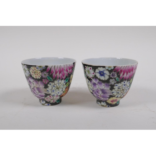 18 - A pair of late C19th/early C20th famille noir porcelain tea bowls with floral decoration, Chinese Gu... 