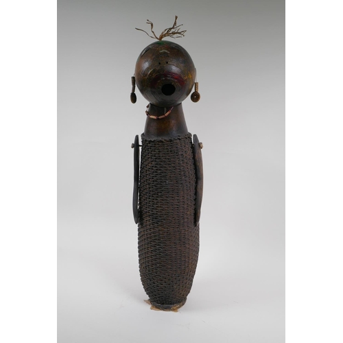 58 - An African basket work and hollowed gourd doll with painted details, possibly Congolese, 59cm high