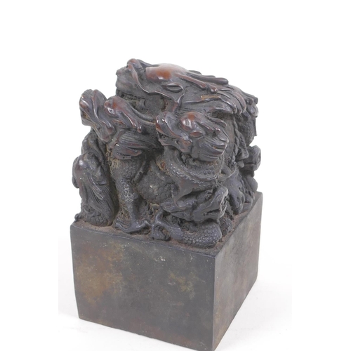 63 - A bronze seal cast with a dragon and young, with Chinese character marks to seal, 8.5cm square, 14cm... 