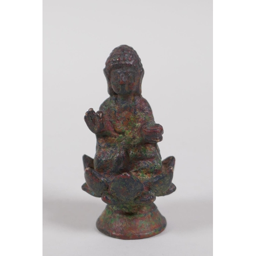 11 - A Tibetan bronze figure of Buddha seated on a lotus flower, 6cm high