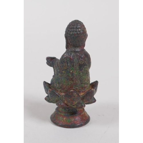 11 - A Tibetan bronze figure of Buddha seated on a lotus flower, 6cm high