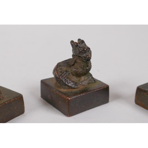 51 - Three Chinese cast bronze seals with zodiac animal mounts, and a bronze ganesh pendant, seals 2.5 x ... 