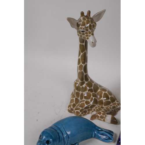 52 - A Szeiler pottery figure of a baby giraffe, 22cm high, a Poole Pottery dolphin, seal and a small pai... 