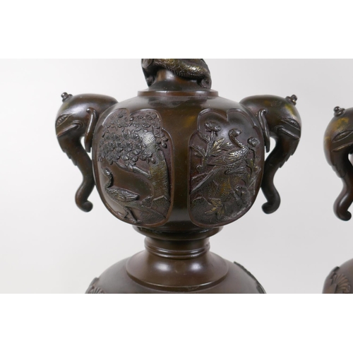 7 - A pair of Meiji bronze stands with elephant mask handles, fo dog and dragon detail and panels depict... 