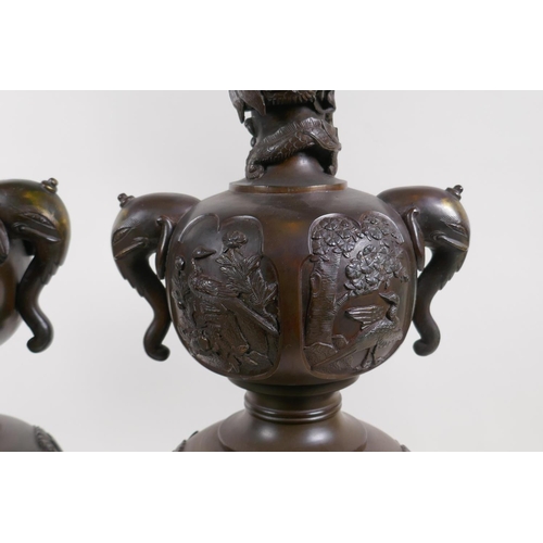 7 - A pair of Meiji bronze stands with elephant mask handles, fo dog and dragon detail and panels depict... 