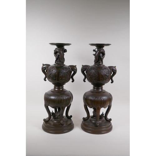 7 - A pair of Meiji bronze stands with elephant mask handles, fo dog and dragon detail and panels depict... 