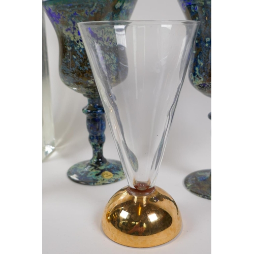 9 - A pair of Polish multi colour pedestal wine glasses, 18cm high, a pair of clear glass flutes on heav... 