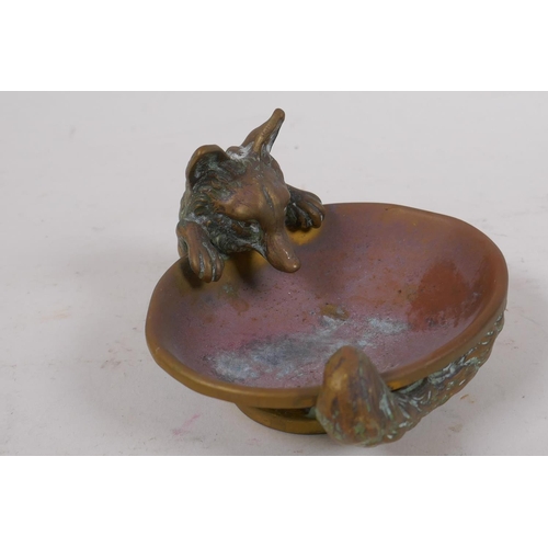 104 - A brass ashtray cast as a fox curled around a water bowl, 10cm wide