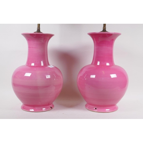 110 - A pair of pink glazed ceramic table lamps, 66cm high