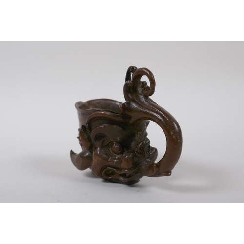 140 - A Chinese bronze libation cup with dragon head decoration, 8 cm high