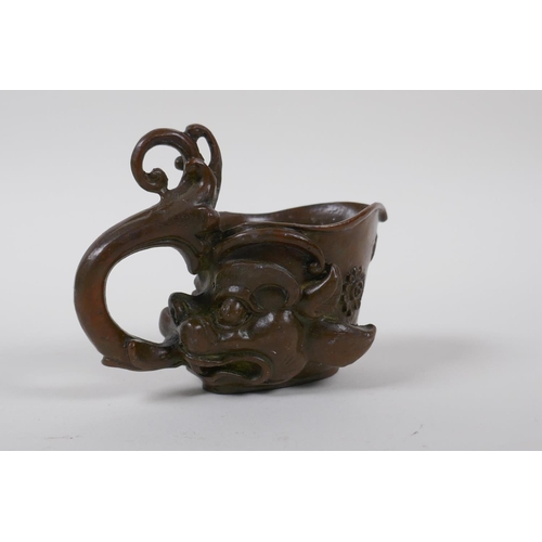 140 - A Chinese bronze libation cup with dragon head decoration, 8 cm high