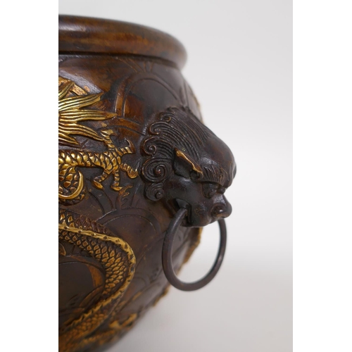 145 - A Chinese bronze censer with two lion mask handles, and raised gilt dragon decoration, 4 character m... 