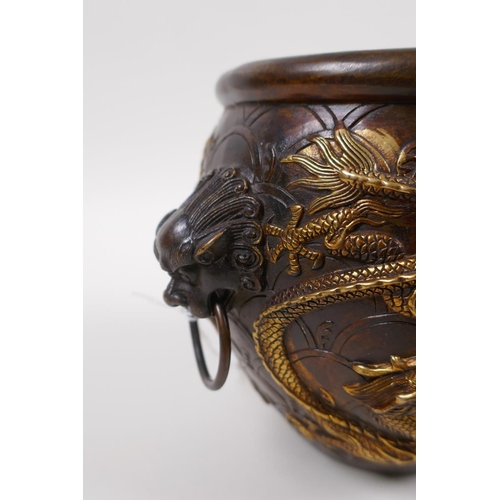 145 - A Chinese bronze censer with two lion mask handles, and raised gilt dragon decoration, 4 character m... 