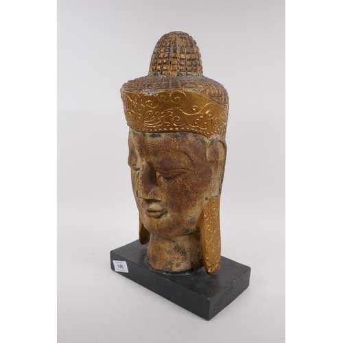 146 - A carved giltwood head of Buddha, 43cm high