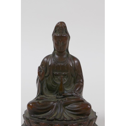 15 - A Chinese bronze of Quan Yin seated on a lotus flower throne, 10cm high