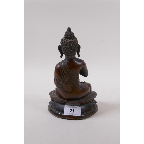 21 - A bronze figure of Buddha seated upon a lotus throne, well patinated, the cast filled with lead, pro... 