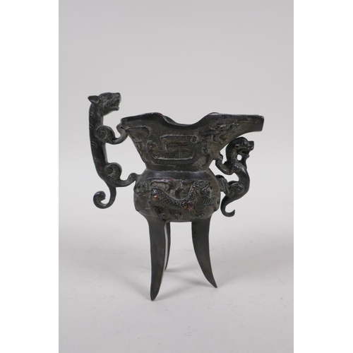 248 - A Chinese bronze Jue (wine vessel), with kylin handle and dragon decoration, 13cm high