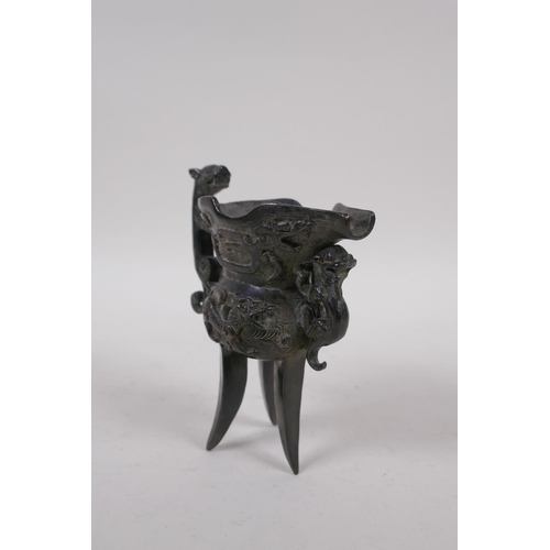 248 - A Chinese bronze Jue (wine vessel), with kylin handle and dragon decoration, 13cm high