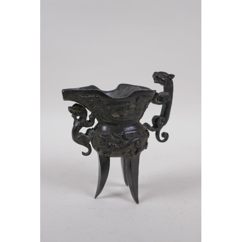 248 - A Chinese bronze Jue (wine vessel), with kylin handle and dragon decoration, 13cm high