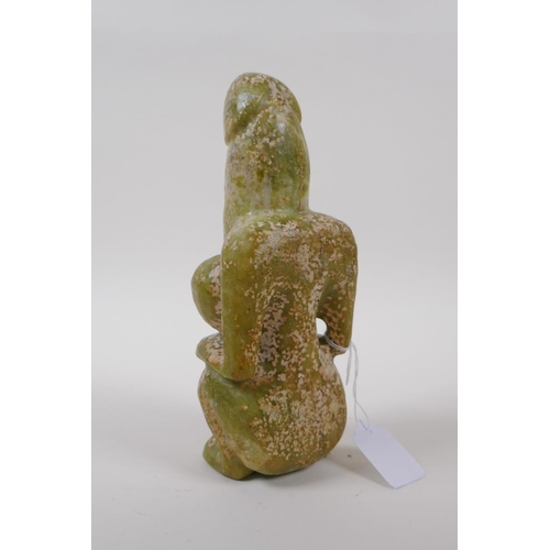 25 - An oriental carved green hardstone fertility figure, 21cm high