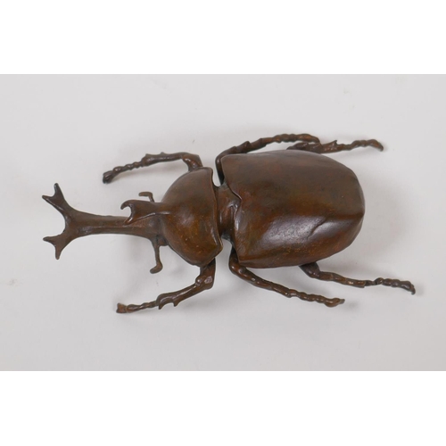 28 - A Japanese Jizai style bronze okimono in the form of a Japanese rhinoceros beetle, 10cm long