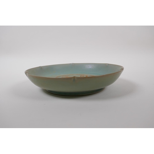 55 - A Chinese celadon glazed porcelain dish with a petal shaped rim and chased dragon decoration, mark t... 