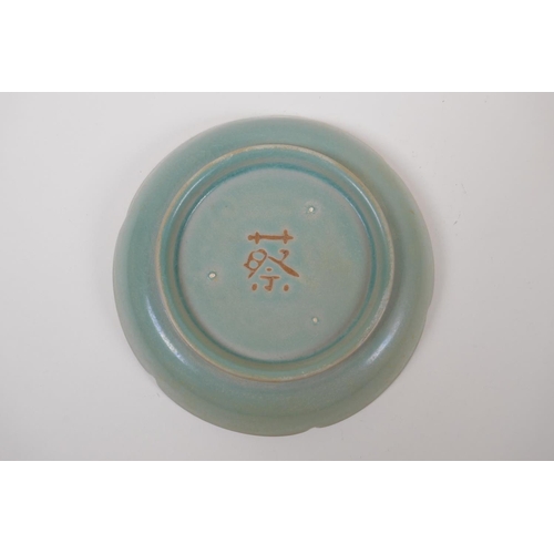 55 - A Chinese celadon glazed porcelain dish with a petal shaped rim and chased dragon decoration, mark t... 