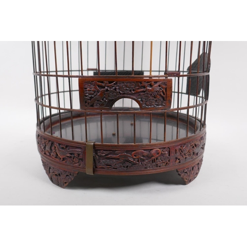 6 - A Chinese bird cage with carved decorative frieze depicting birds and squirrels amongst foliage, ben... 