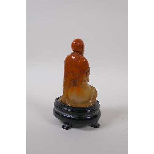 75 - A Chinese soapstone style composition figure of Lohan with a seal to base, with display stand and bo... 