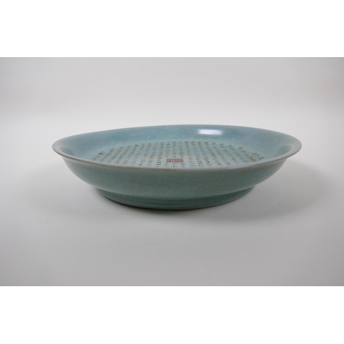 85 - A Chinese celadon crackle glazed porcelain shallow dish with all over chased and gilt character insc... 