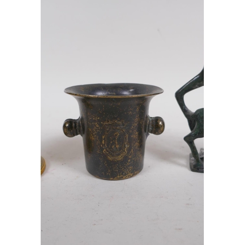 9 - A brass goblet with engraved decoration, a mortar shaped vessel, 10cm high, and a stylised figure of... 