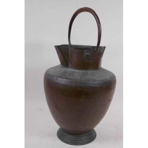 97 - An eastern copper water jug with double spout and loop handle, 40cm high