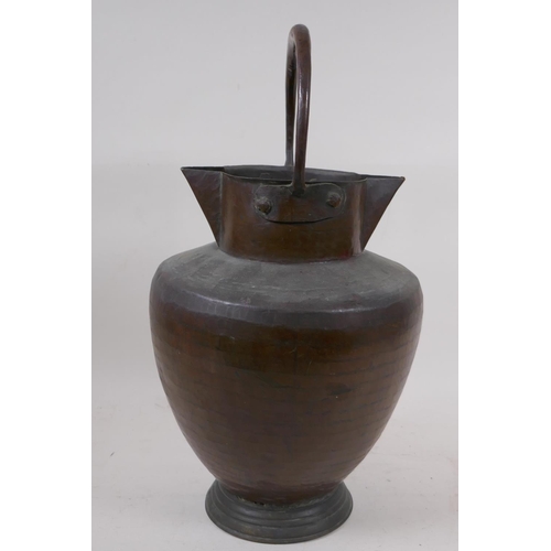 97 - An eastern copper water jug with double spout and loop handle, 40cm high