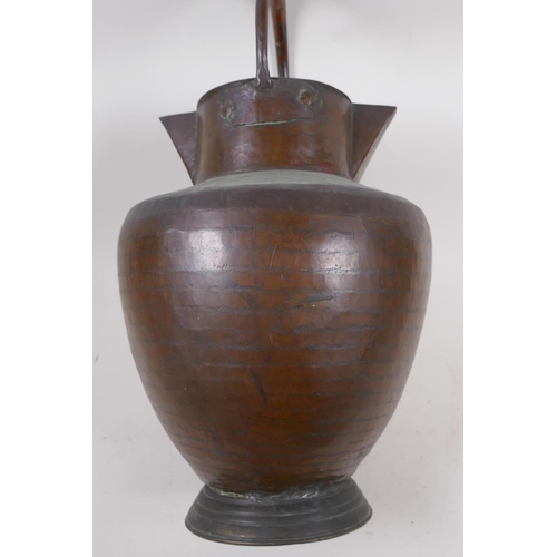 97 - An eastern copper water jug with double spout and loop handle, 40cm high