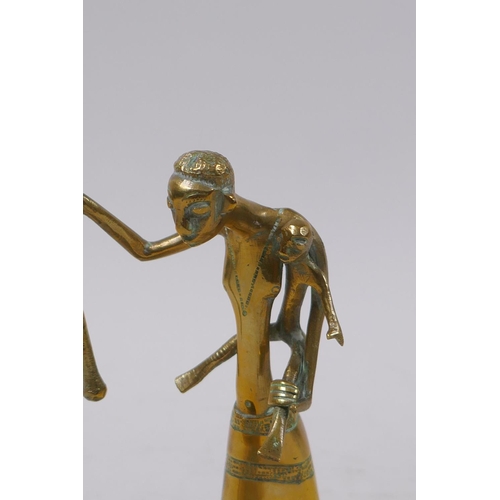 11 - An African Benin style brass figure of a mother carrying a child and using a pestle and mortar, 13cm... 